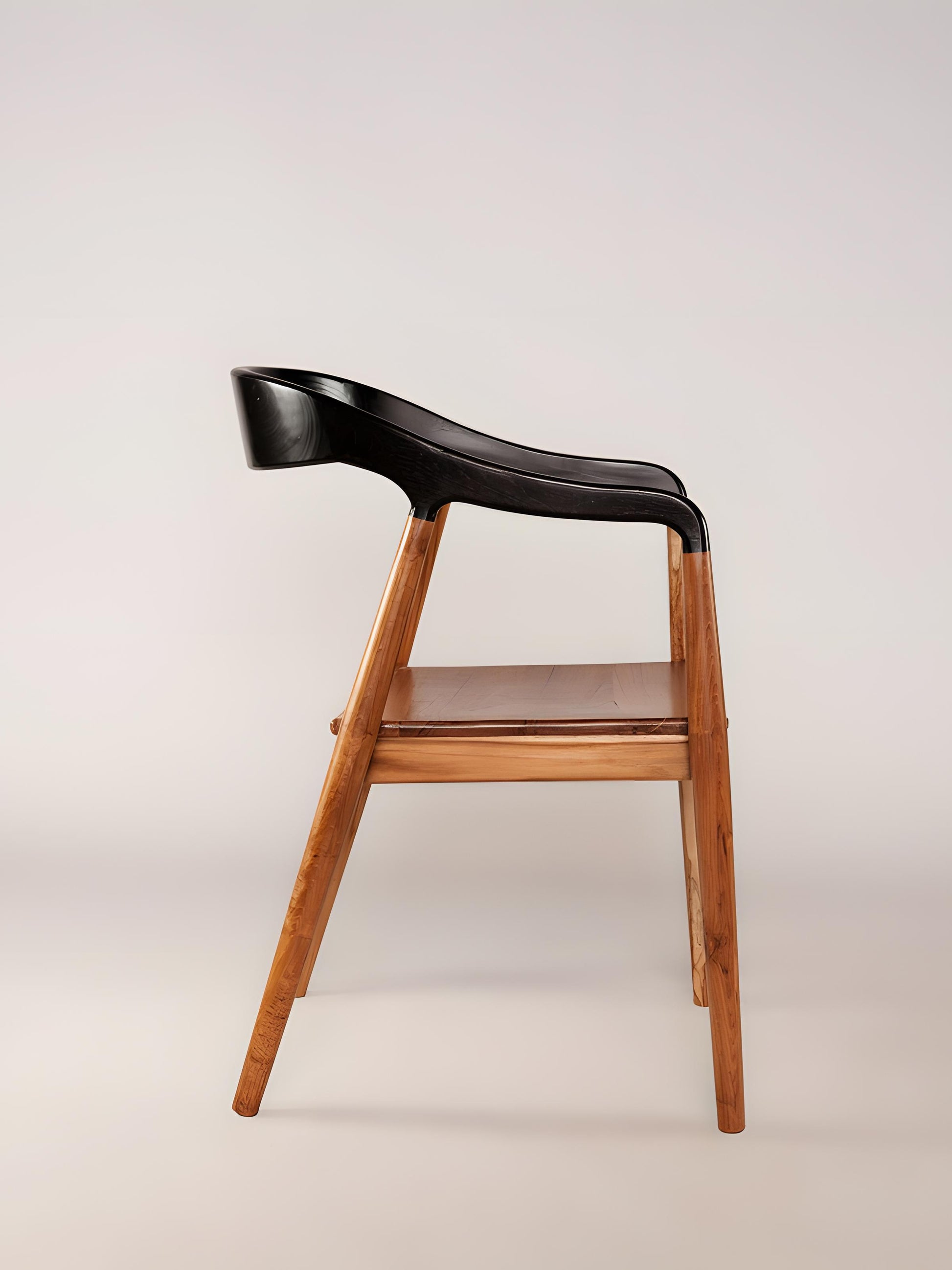 Side profile of Jacobo teak wood dining chair with curved back and armrests in dark choco finish | Mellowdays Furniture