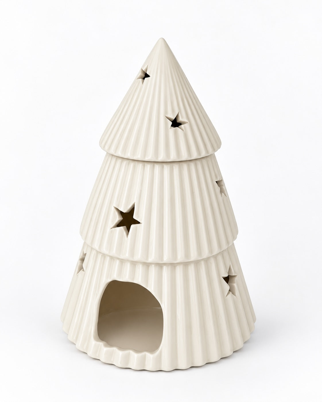 An off-white ceramic Christmas tree-shaped oil burner / wax warmer with ribbed tiers and star-shaped cutouts
